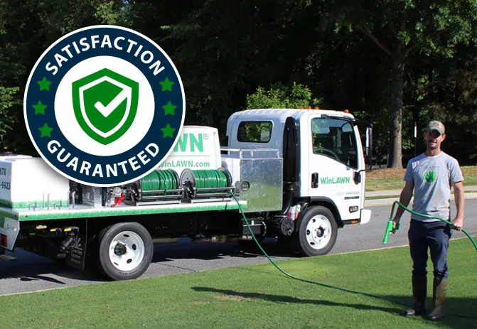 Tech standing in front of truck on green healthy lawn