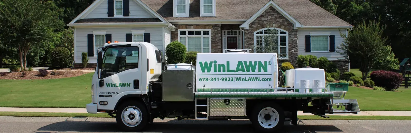 WinLAWN truck parked in front of ranch style home with green healthy grass